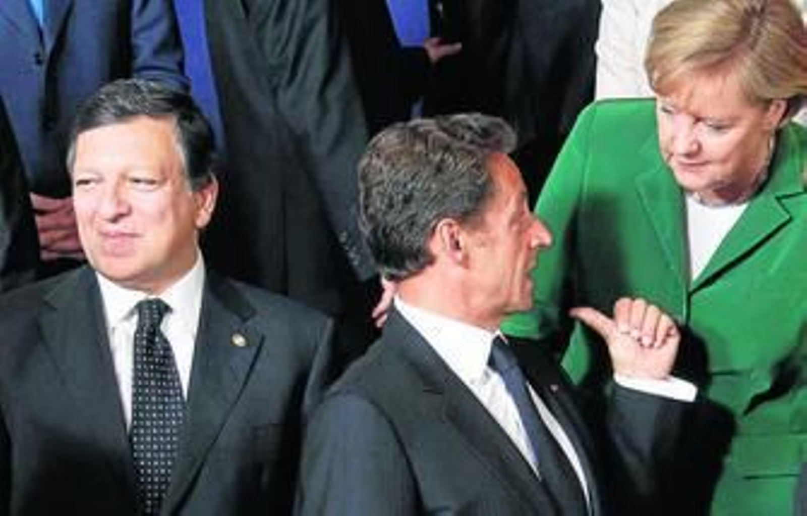 Los mandatarios francés, Sarkozy, y alemana, Merkel, hablan ante el presidente de la Comisión, Barroso.