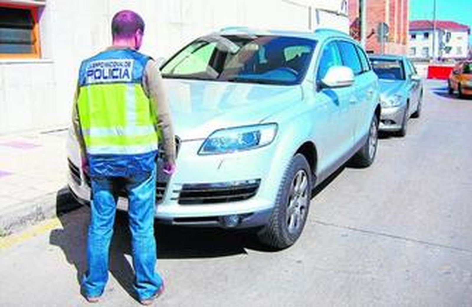 Un agente en la Comisaría Provincial de Málaga junto a varios vehículos robados.