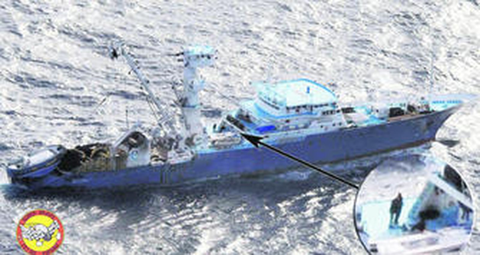 El atunero Alakrana, el pasado viernes, con la imagen ampliada de uno de los secuestradores.