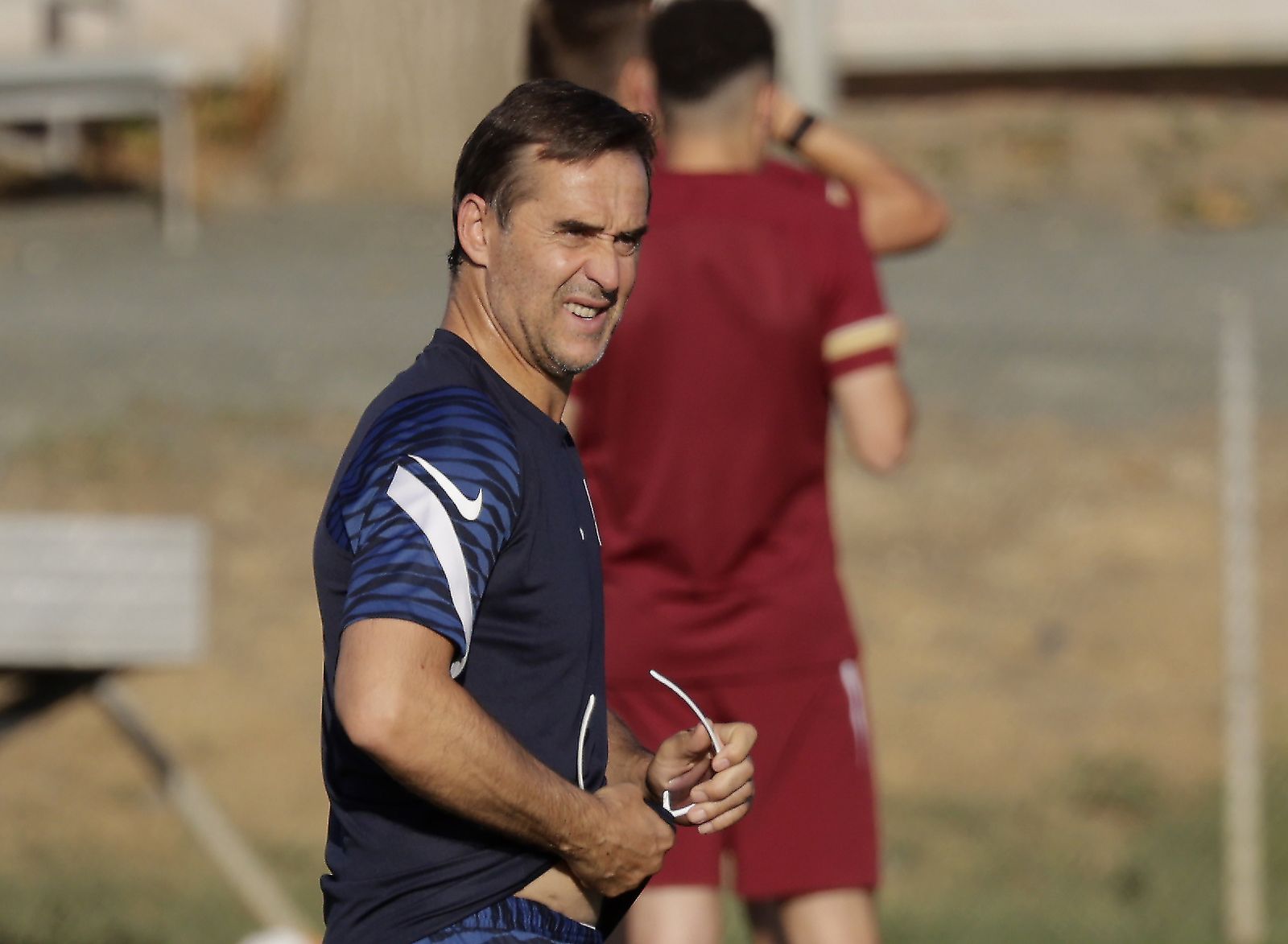 Julen Lopetegui se limpia las gafas para evitar el bajo sol.