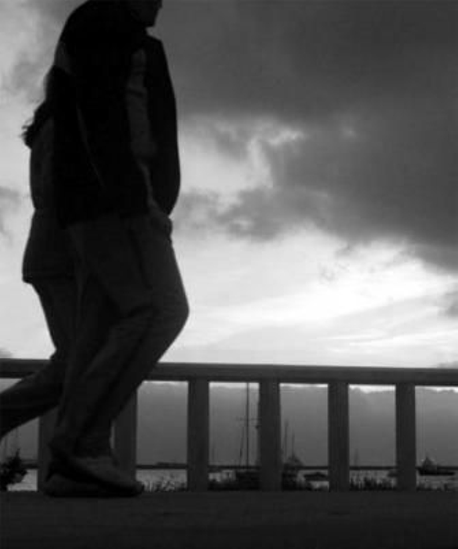 Dos personas caminan por el paseo marítimo de Poniente.