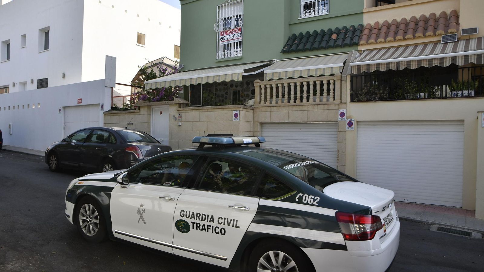 Una patrulla de la Guardia Civil en la puerta de la vivienda del doctor con el cartel de "Se vende"