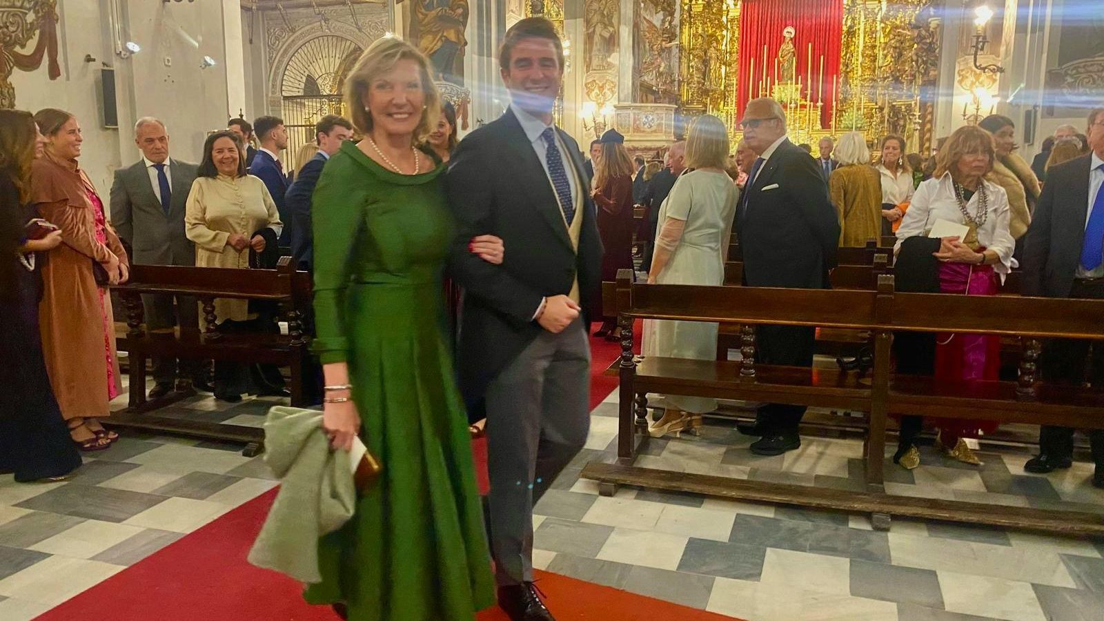 Macarena Olivencia, madre de la novia, del brazo de su hijo Javier