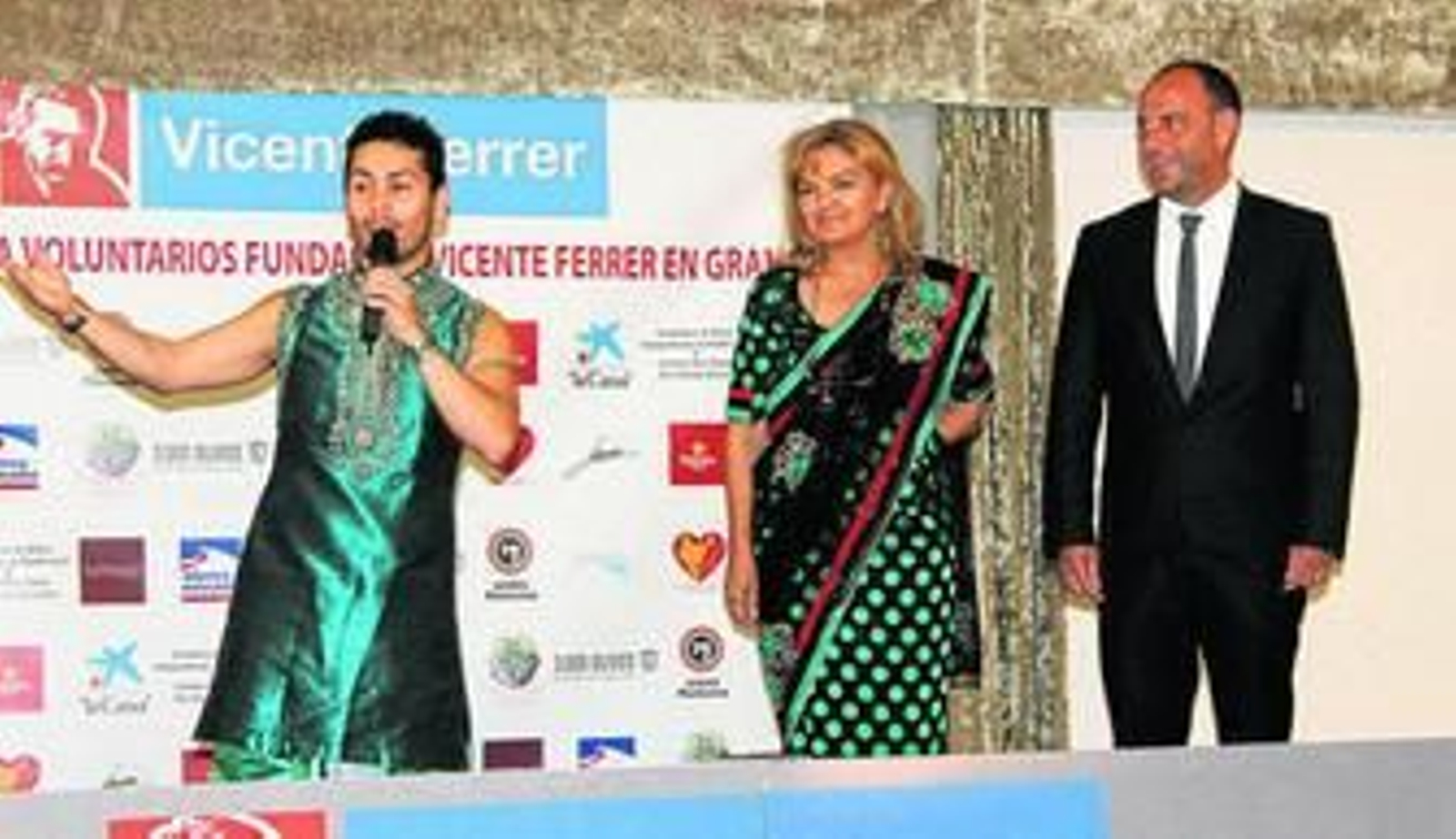 'En la imagen principal, Carmen Corpas y Rafael Carmona, durante el acto. Sobre estas líneas, el mercadillo solidario que se instaló en el salón de celebraciones. Abajo, cuadro y colcha subastados. A la derecha, cartel de la carrera solidaria.