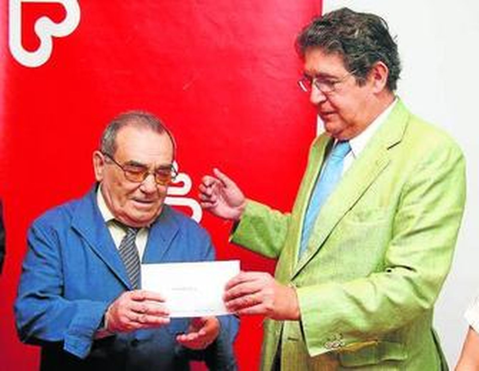 Felipe Cecilia recibe el cheque de manos de José Joaquín Gallardo.
