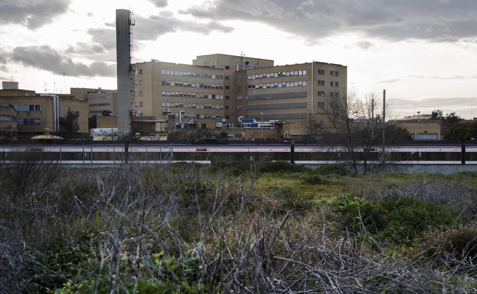 Vista del solar de la calle Manuel Laffón  con el apeadero de Cercanías y el Hospital Virgen del Rocío al fondo.