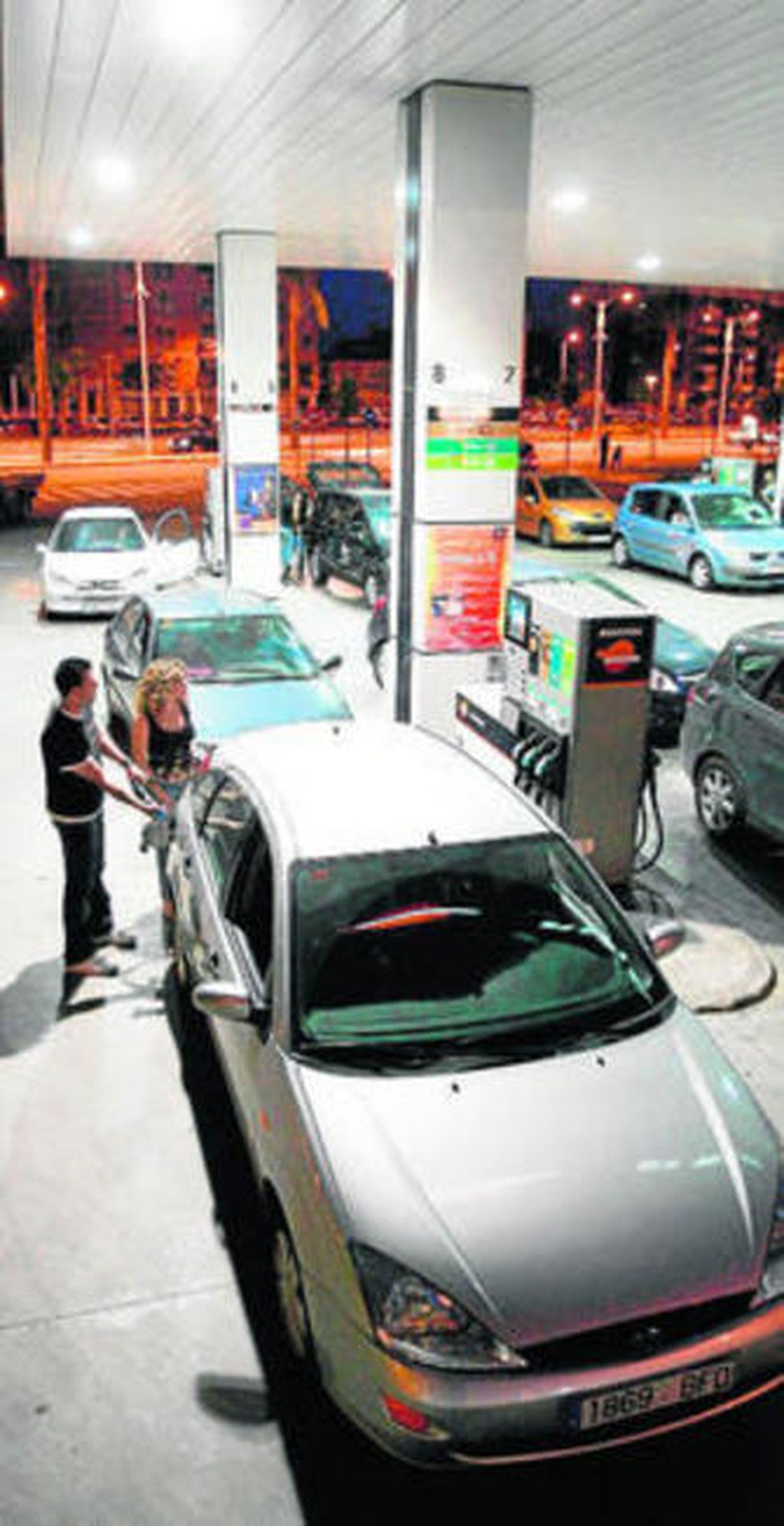 Unos usuarios repostan en una gasolinera.