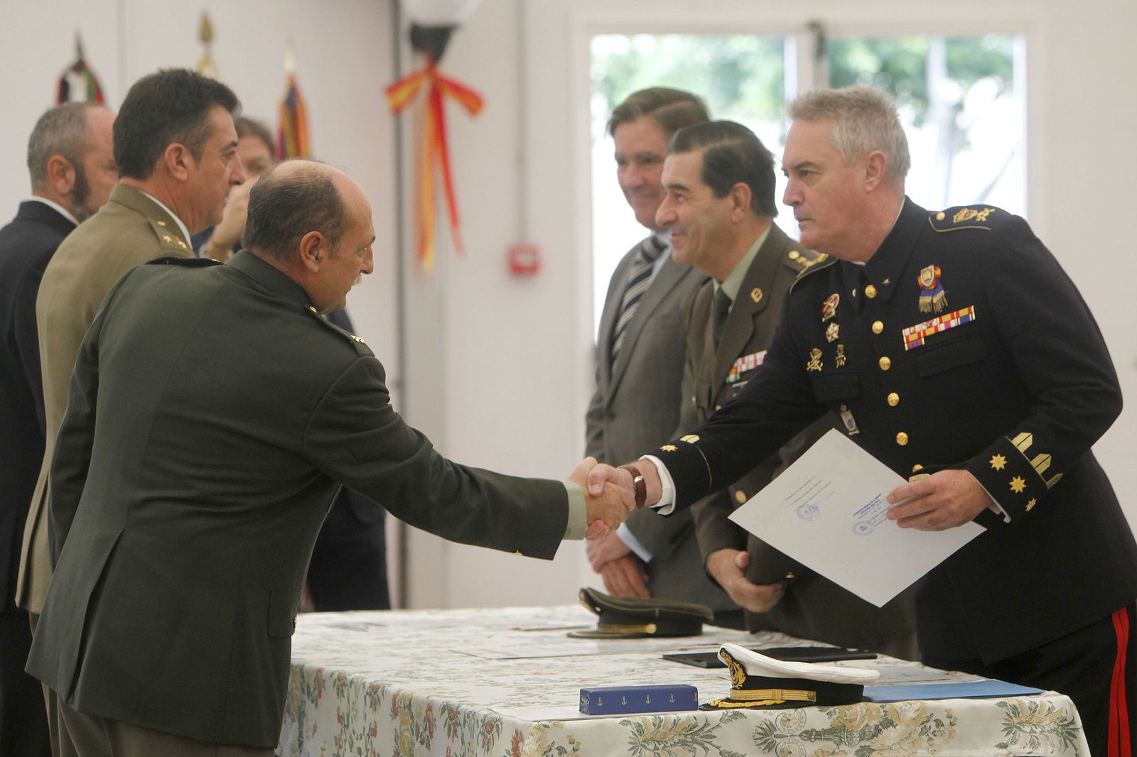 El subdelegado de Defensa en Cádiz da la mano a uno de los condecorados ayer en el acto.