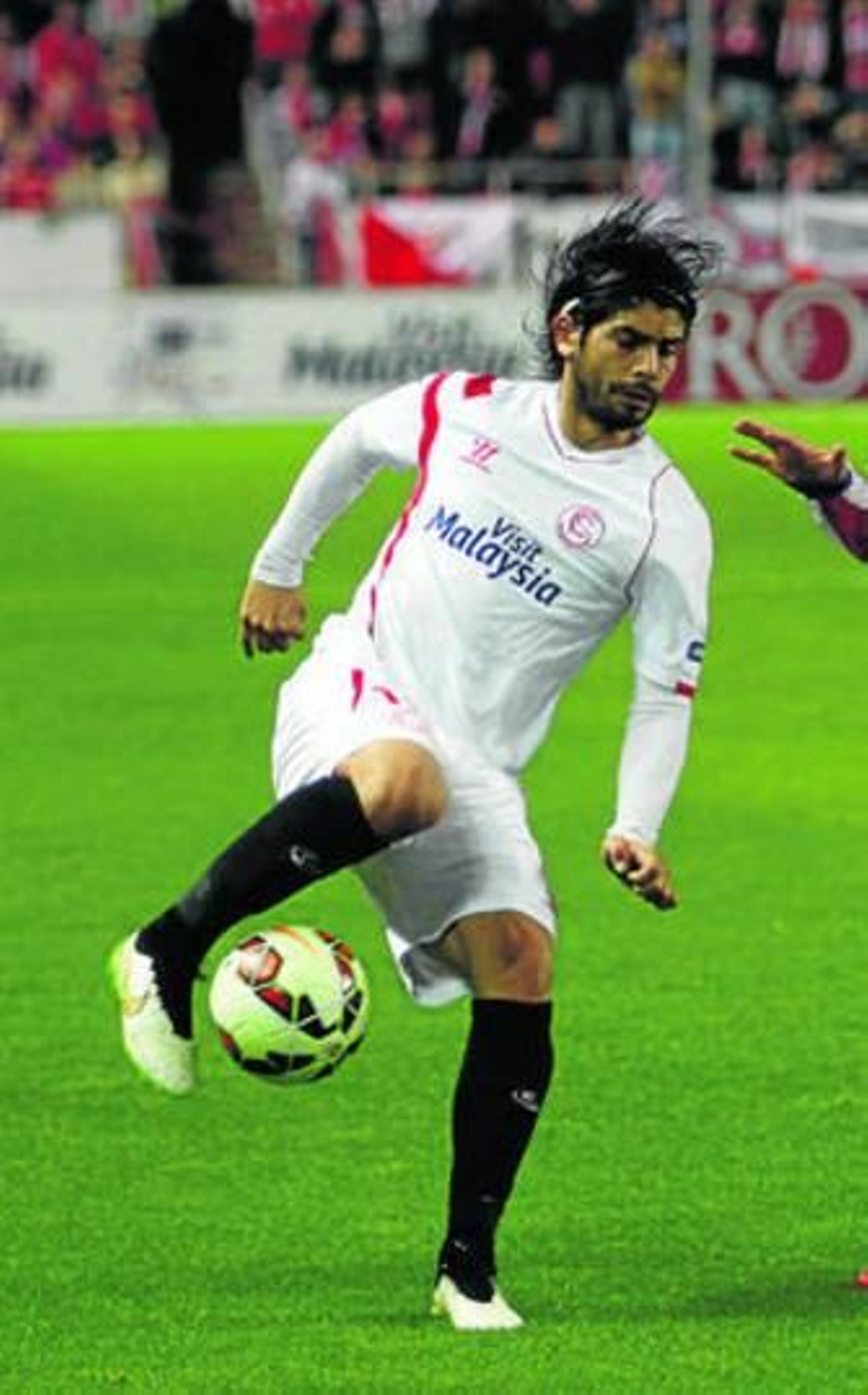 Éver Banega recorta con una espuela interior para salvar la presión de un jugador atlético.
