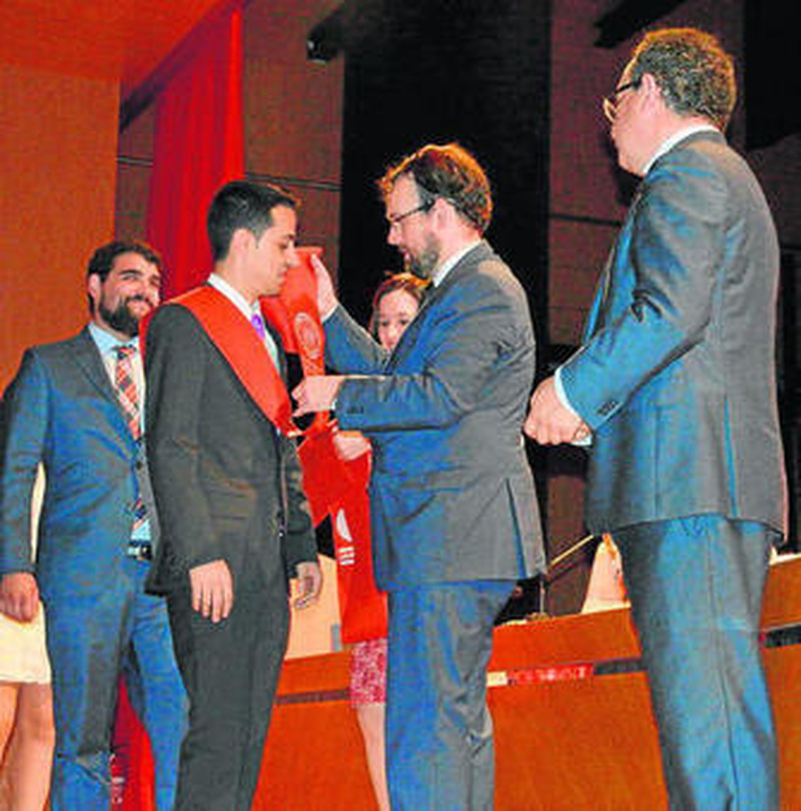 Los jóvenes estudiantes recogen sus bandas de mano de sus profesores y responsables de la facultad de Derecho.