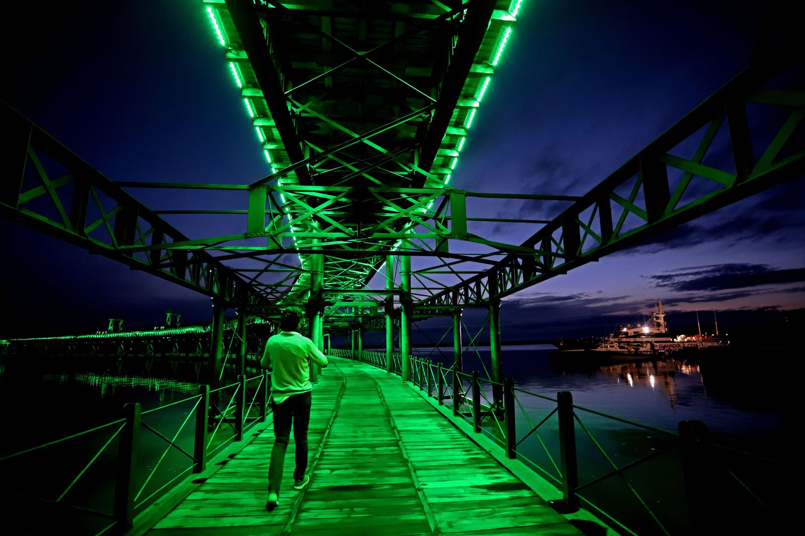 El muelle de la Riotinto se ilumina de verde en el día mundial contra el cancer