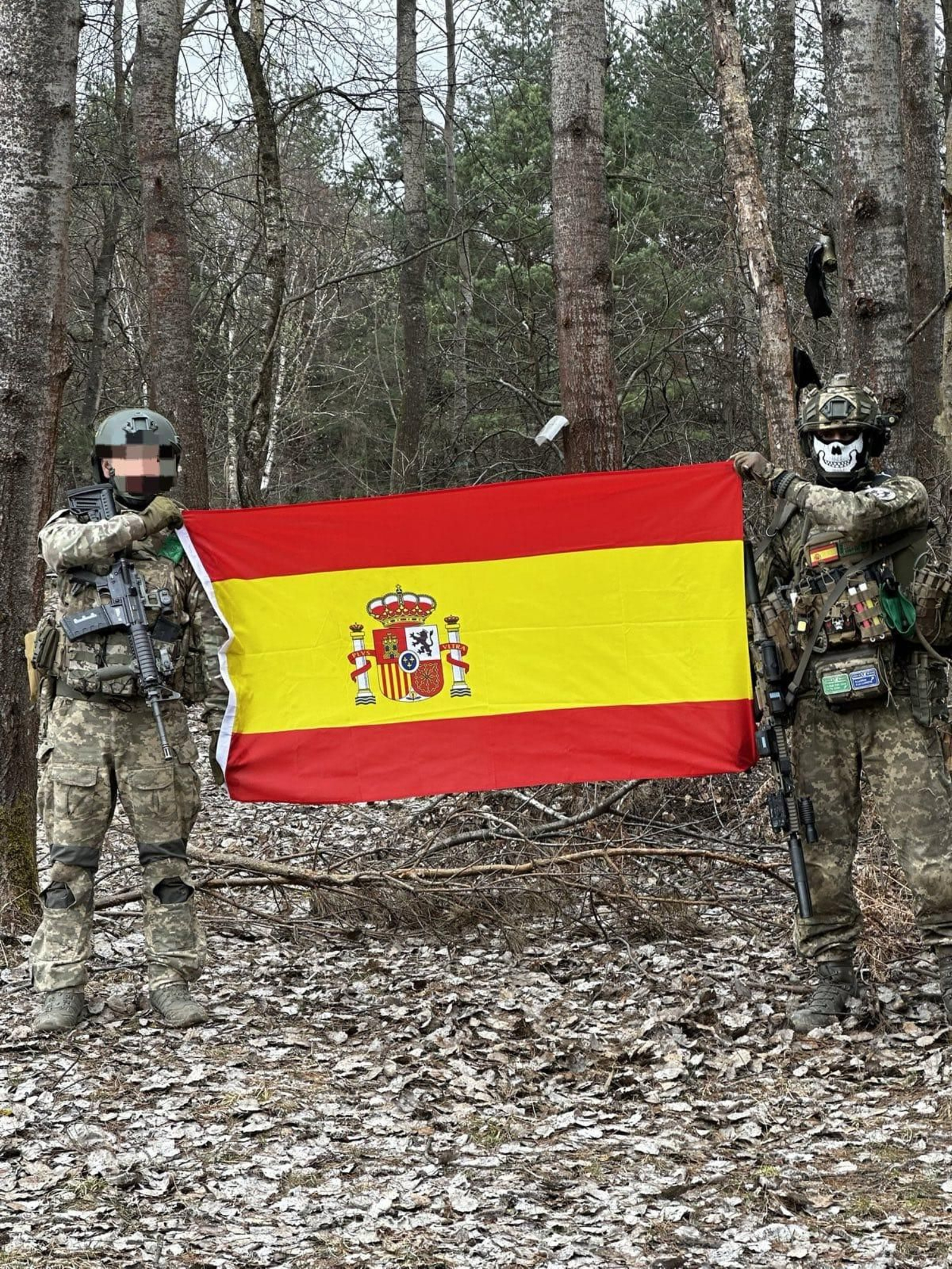 Ren, a la derecha, exhibe junto a otro combatiente, una bandera de España en zona de combate. Ren, a la derecha, exhibe junto a otro combatiente, una bandera de España en zona de combate.
