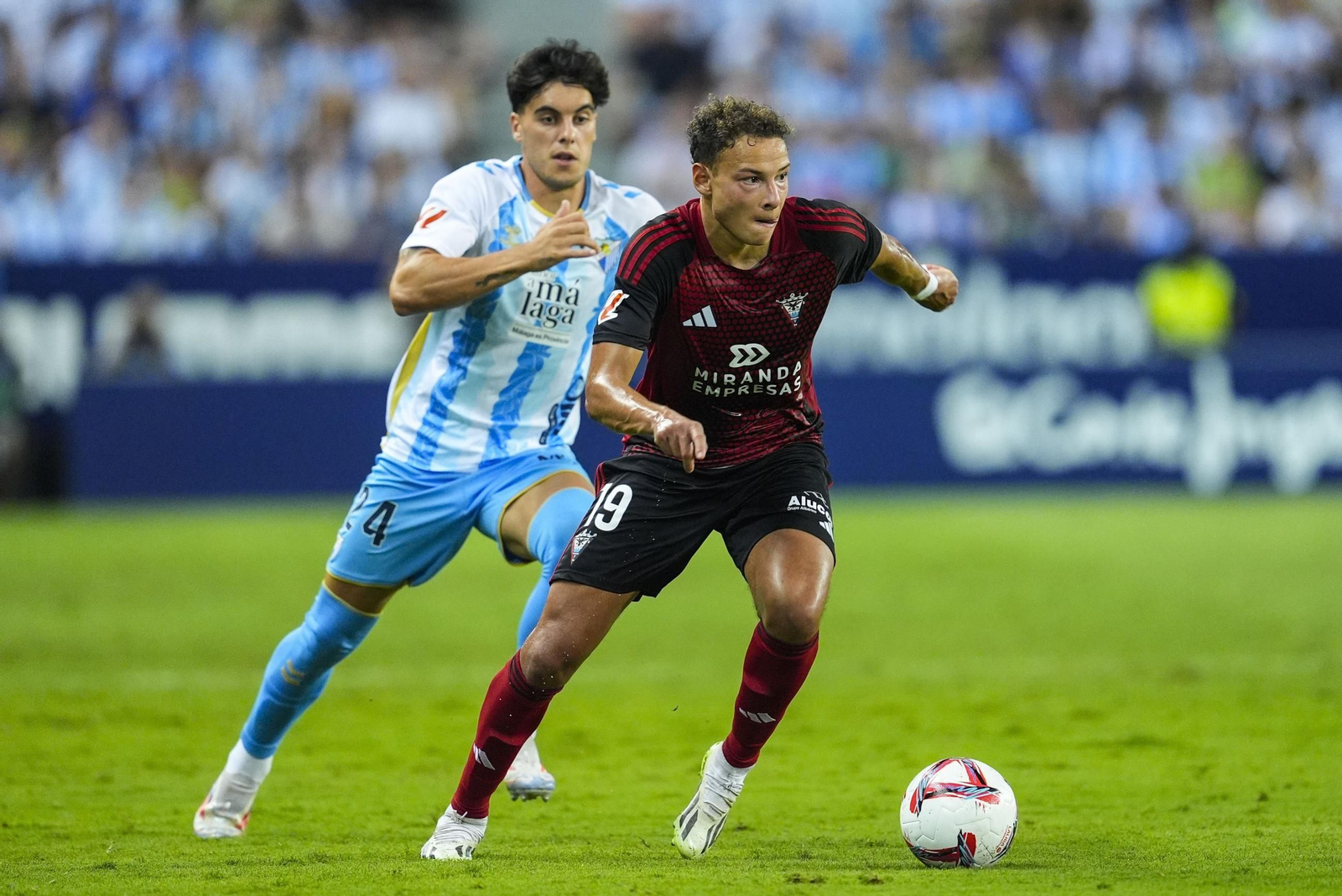 Mathis Laucher conduce el balón perseguido por el malaguista Julen Lobete, en un partido de la pasada temporada.