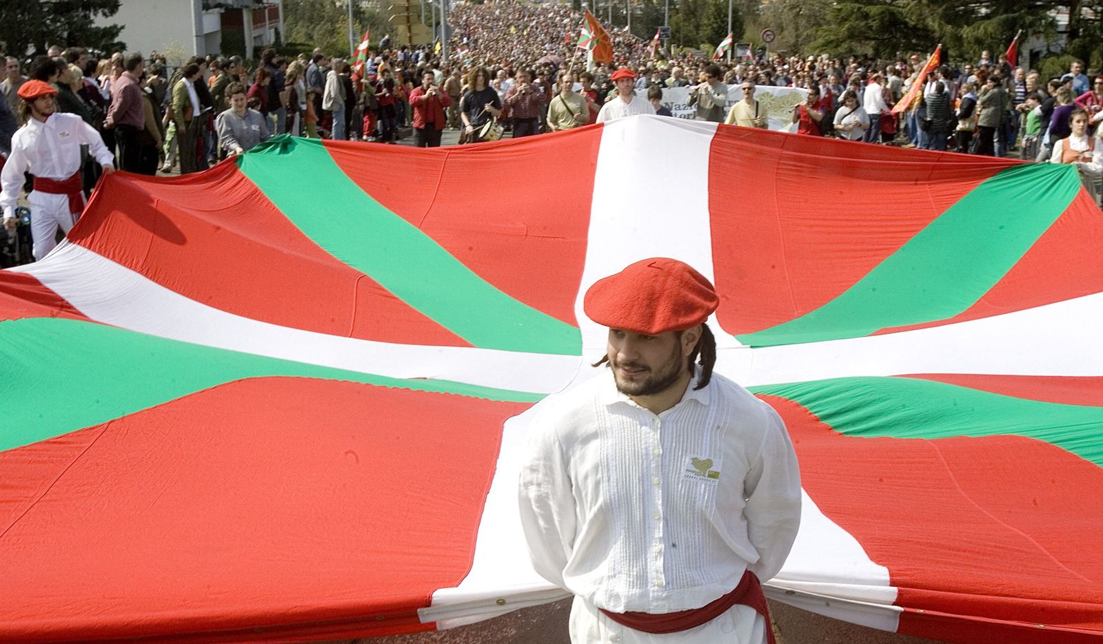 Unos 'dantzaris' despliegan la ikurriña  el día de la patria vasca.