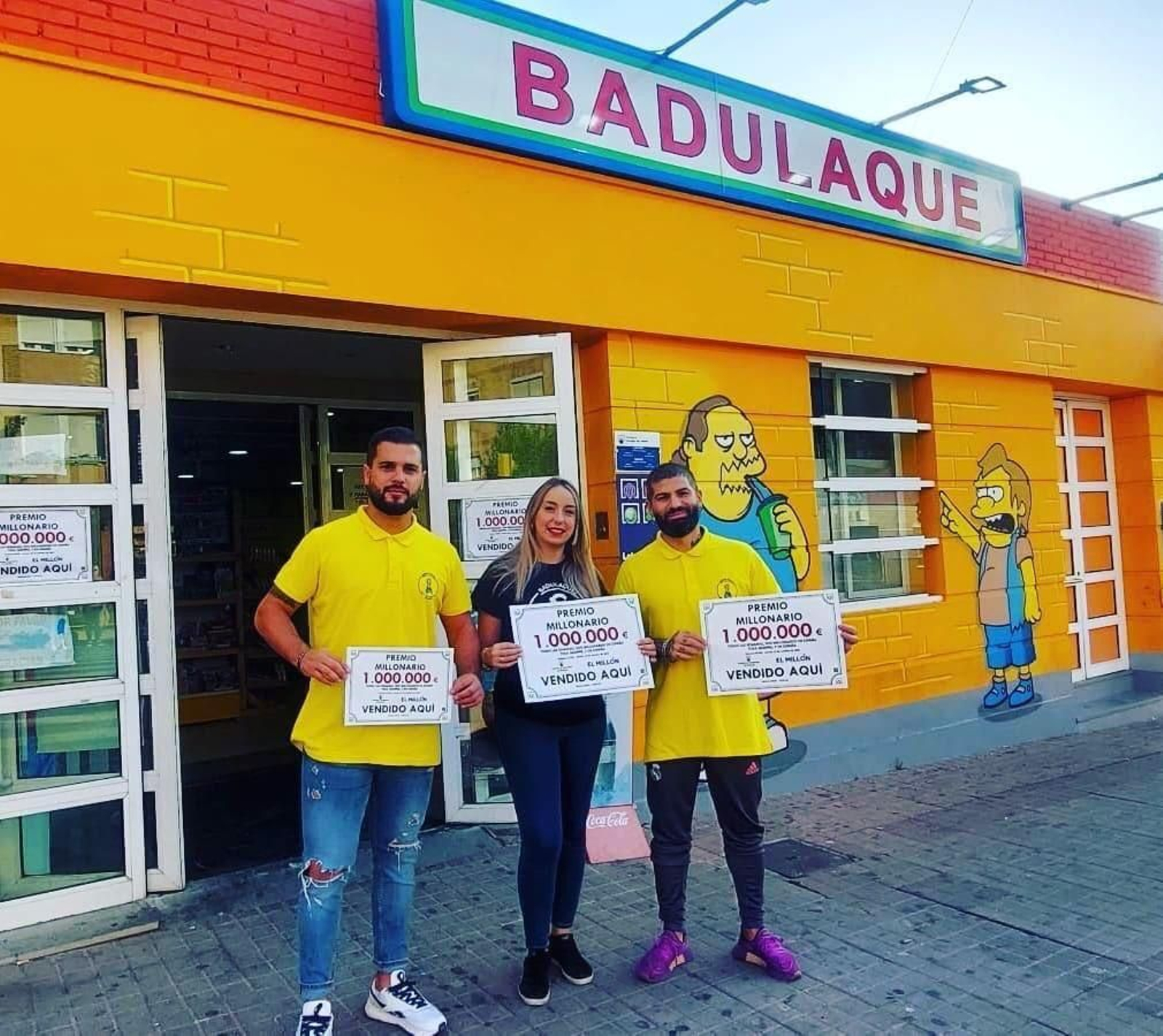 Responsables del despacho receptor portan carteles con el premio dado este martes.