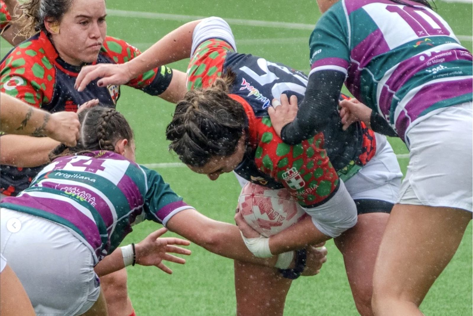 Una jugadora del conjunto almeriense intenta avanzar con el oval ante el bloqueo de una rival.