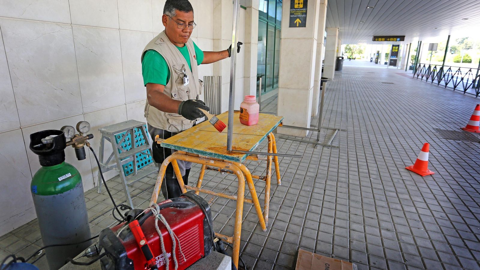 Un operario preparando una de las mamparas que se colocarán en los mostradores.