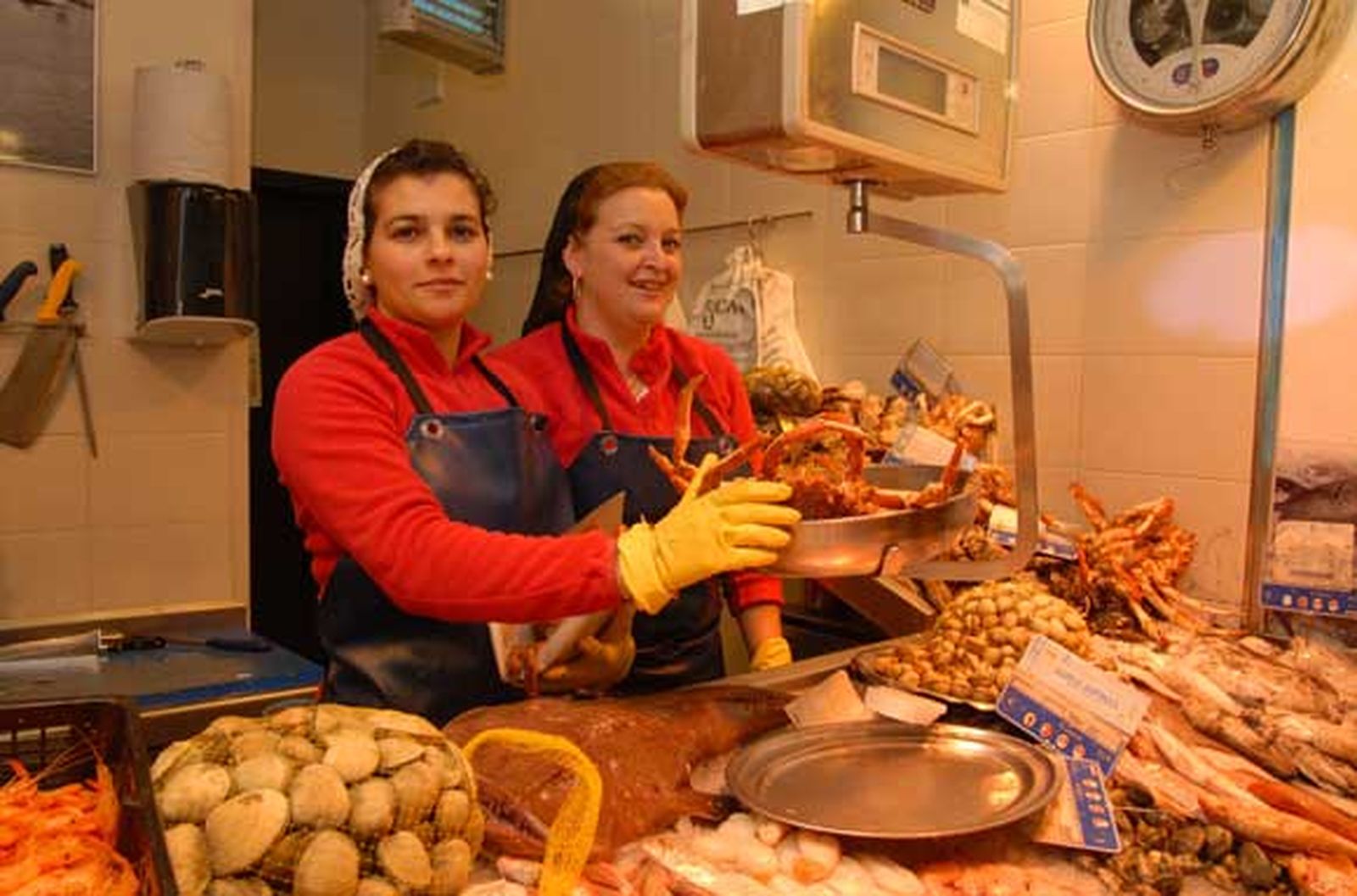 Pescadería Ricardo
Propietario: Jesús María Gómez Rodríguez · Su hermana, Gema Gómez y su cuñada, Ana Belén Galindo 
trabajan en el puesto
Puesto P-13
Género:Presumen de tener siempre pescado fresco
Tanto Gema como Ana Belén quieren destacar que el pescado que venden en su puesto de la plaza es “fresco, nada congelado”. Ofrecen almejas gallegas, salmonete, pulpo, breca, mojarras,  merluza blanca, gambas de la zona, berberecho gallego y atún fresco cocido, sin conservantes y envasado al vacío. 
Su especialidad es el pescado de la Bahía de Cádiz, pero también tienen en su expositor pescado y marisco de Sanlúcar, Huelva y Barbate. 


Foto: Paco Periñán