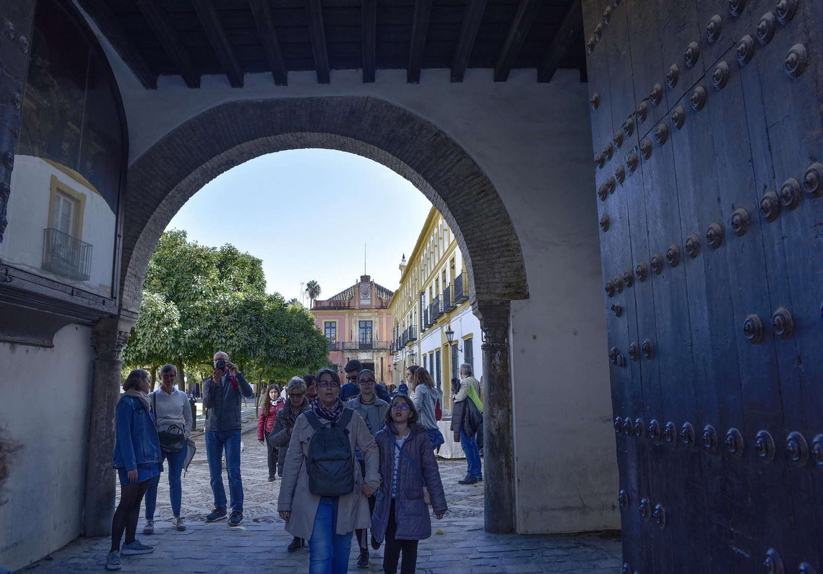 Turistas acceden al barrio de Santa Cruz desde el Patio de Banderas.