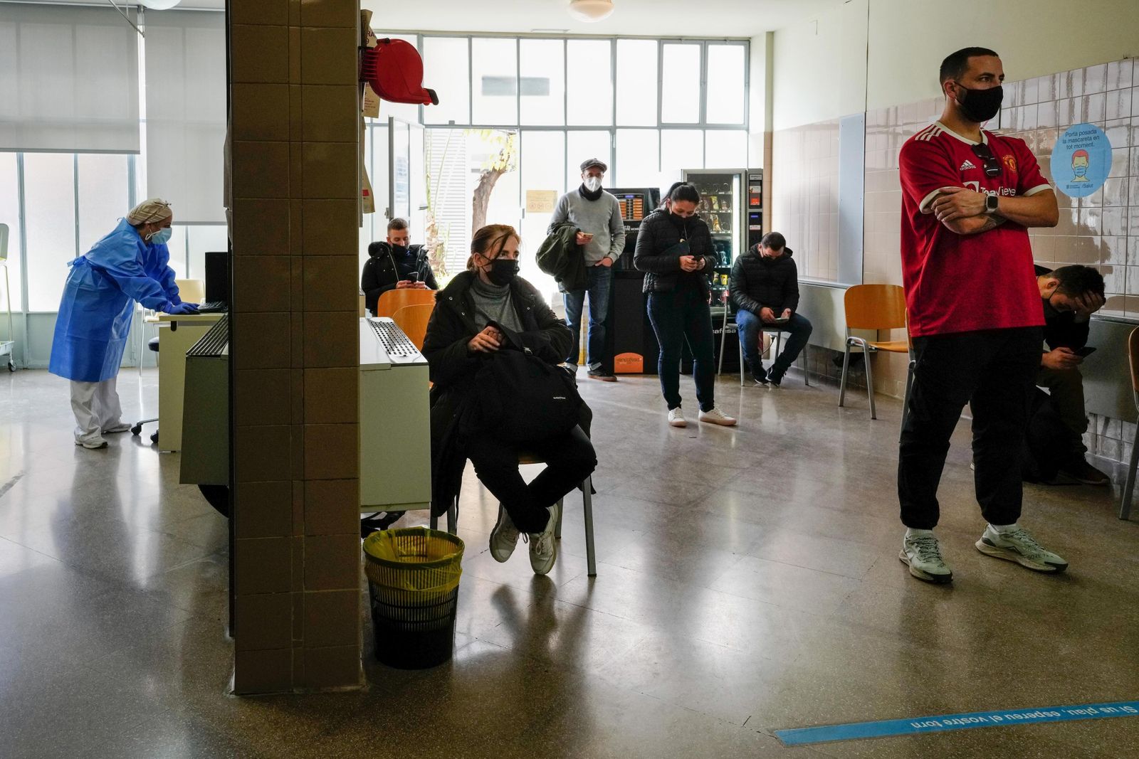 Varias personas esperan turno en un centro de vacunación de Barcelona