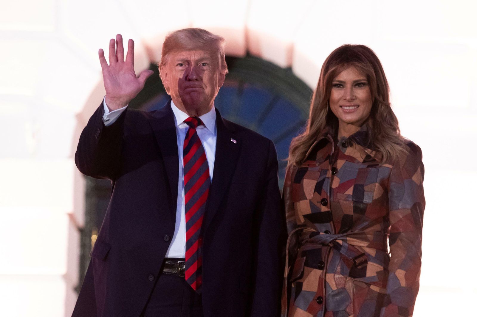 Melania Trump, con gabardina de Michael Kors, junto a su marido en la recepción de Halloween en la Casa Blanca.