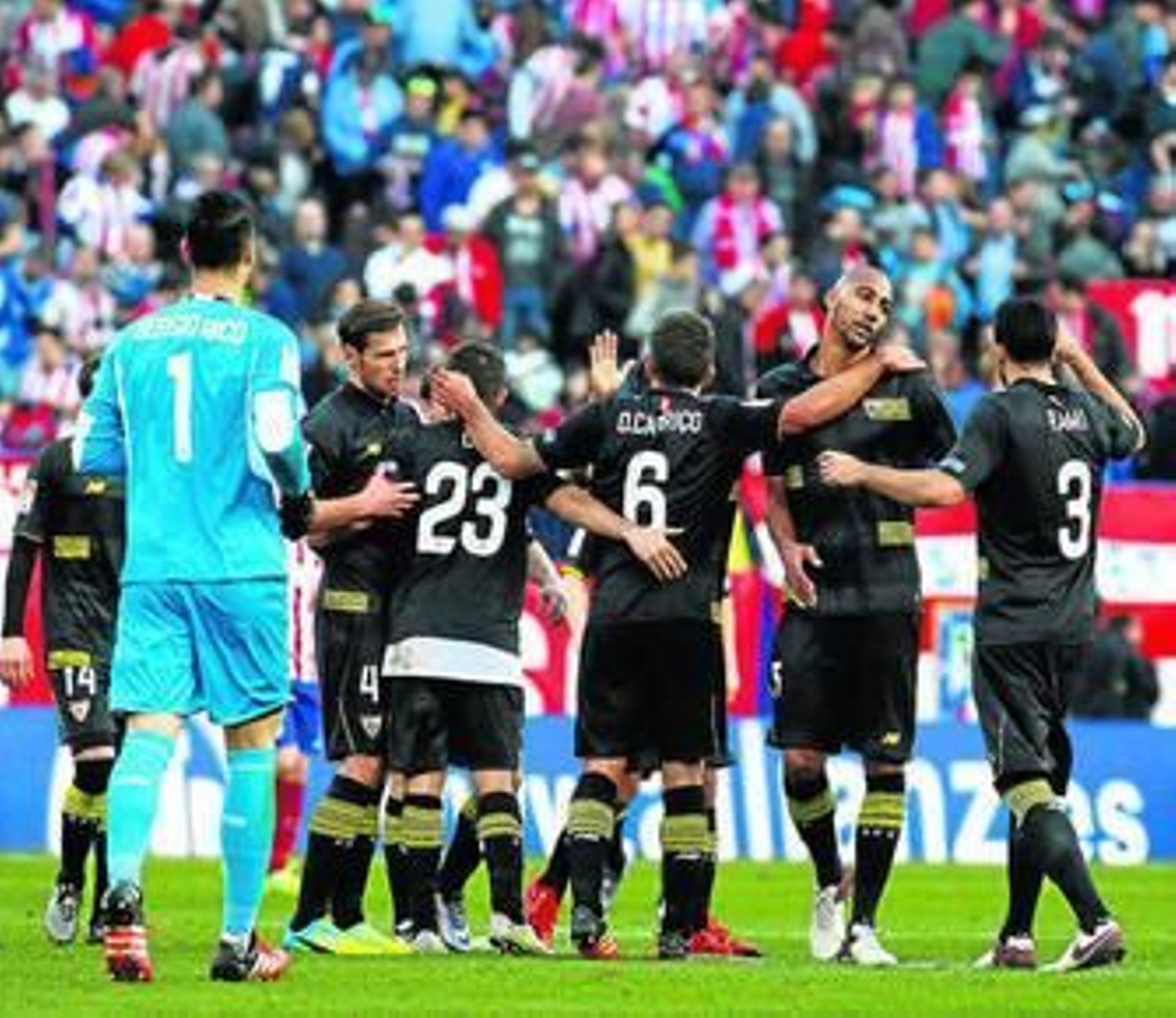 Sergio Rico se acerca al corro de jugadores del Sevilla, que celebran el punto logrado en inferioridad.