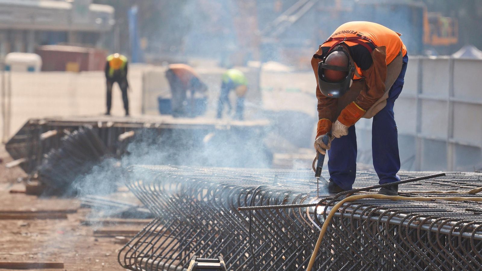 Obrero suelda la ferralla en plena calle.