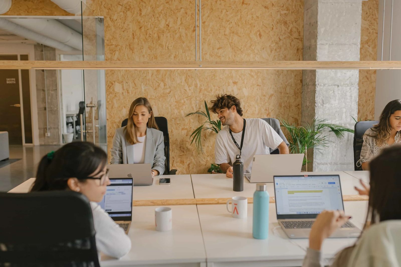 Varios trabajadores frente a sus ordenadores en una oficina.