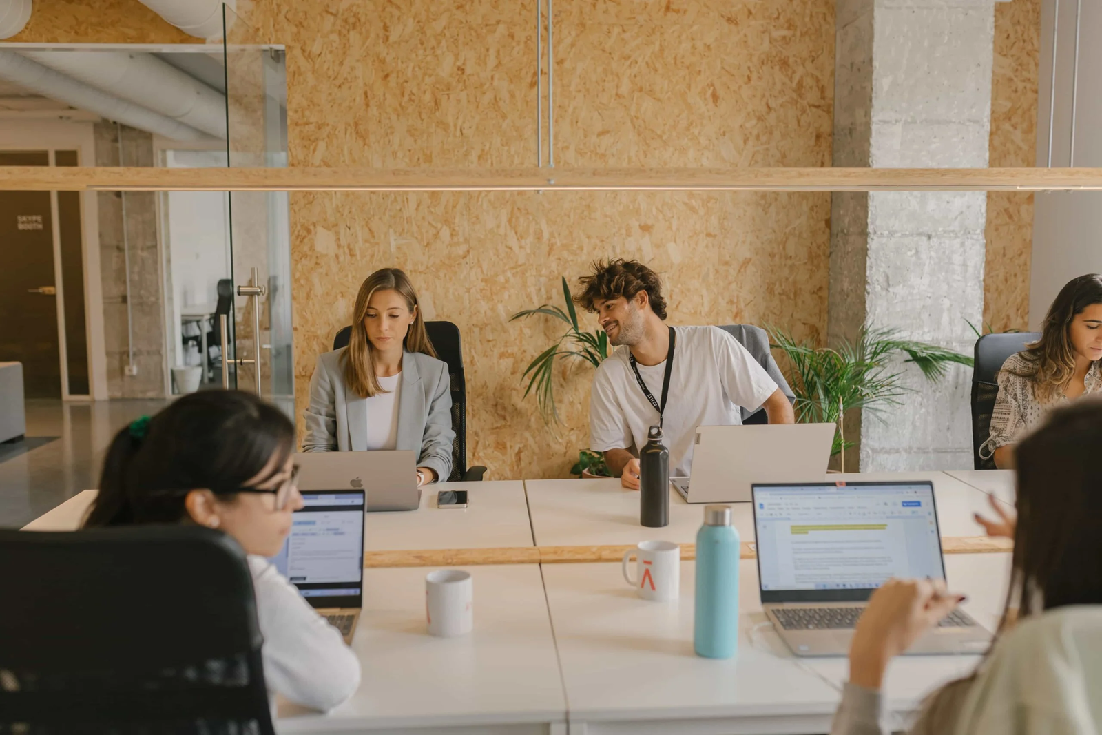 Varios trabajadores frente a sus ordenadores en una oficina.
