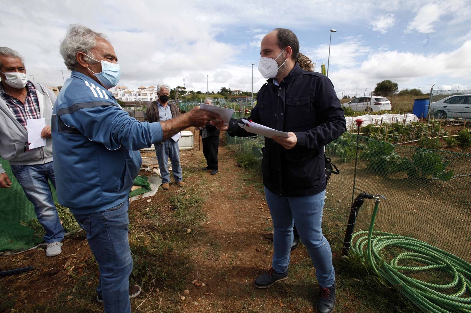 El alcalde en funciones de Ayamonte, Javier López, entrega los sobres con semillas a uno de los hortelanos