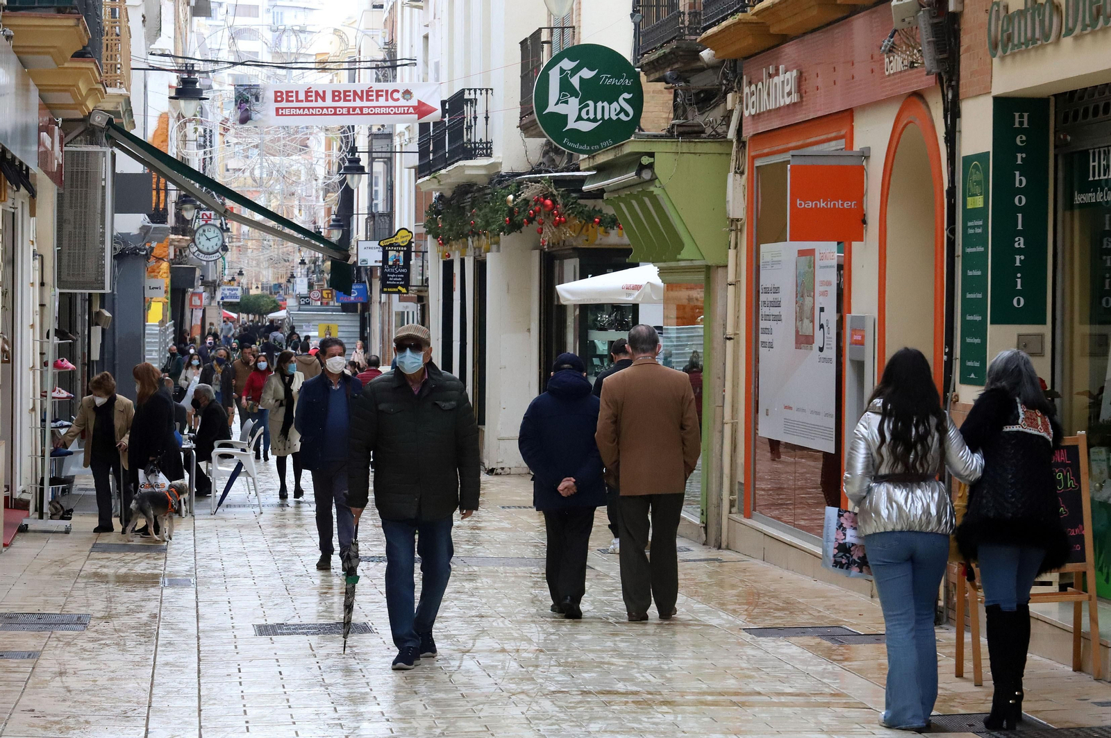 Varias personas pasean por una de las principales calles comerciales de Huelva.