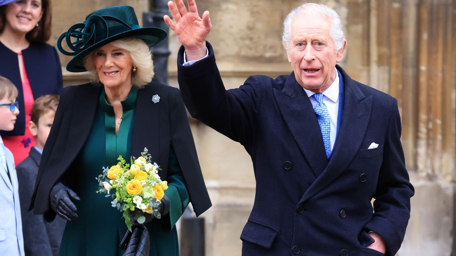 Carlos III, acompañado por la reina Camila, saluda a su salida de misa en la iglesia de San Jorge del castillo de Windsor.