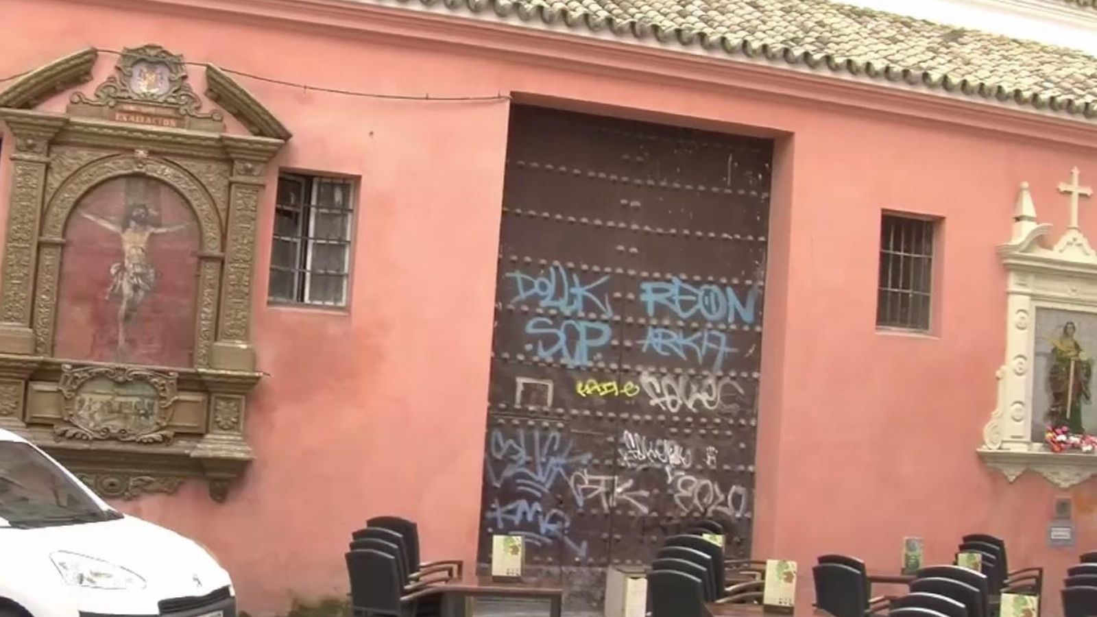 La puerta por la que salen los pasos en Semana Santa llena de pintadas.