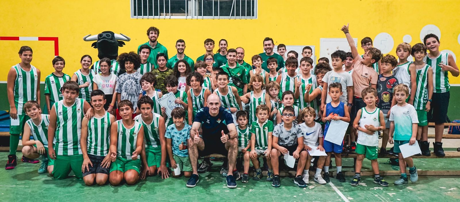 Javi Carrasco, rodeado de niños en una visita de jugadores y del club al colegio Aljarafe.