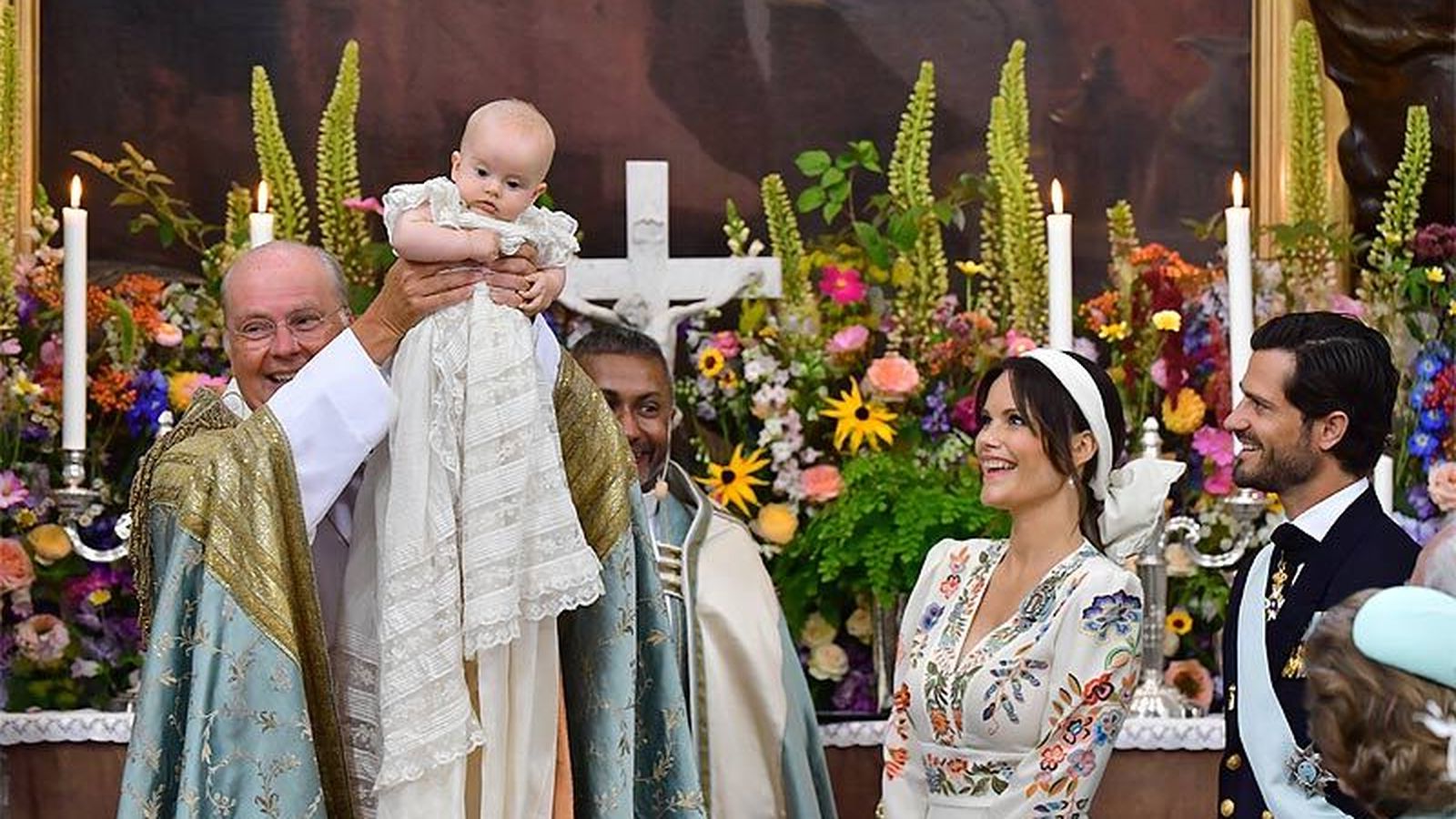 El sacerdote levanta al bebé tras recibir las aguas bautismales este sábado en Estocolmo.