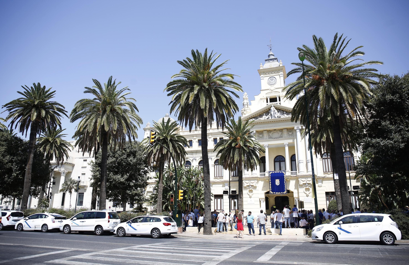 Taxistas concentrados enfrente del Ayuntamiento, son sus coches estacionados en el Paseo del Parque.