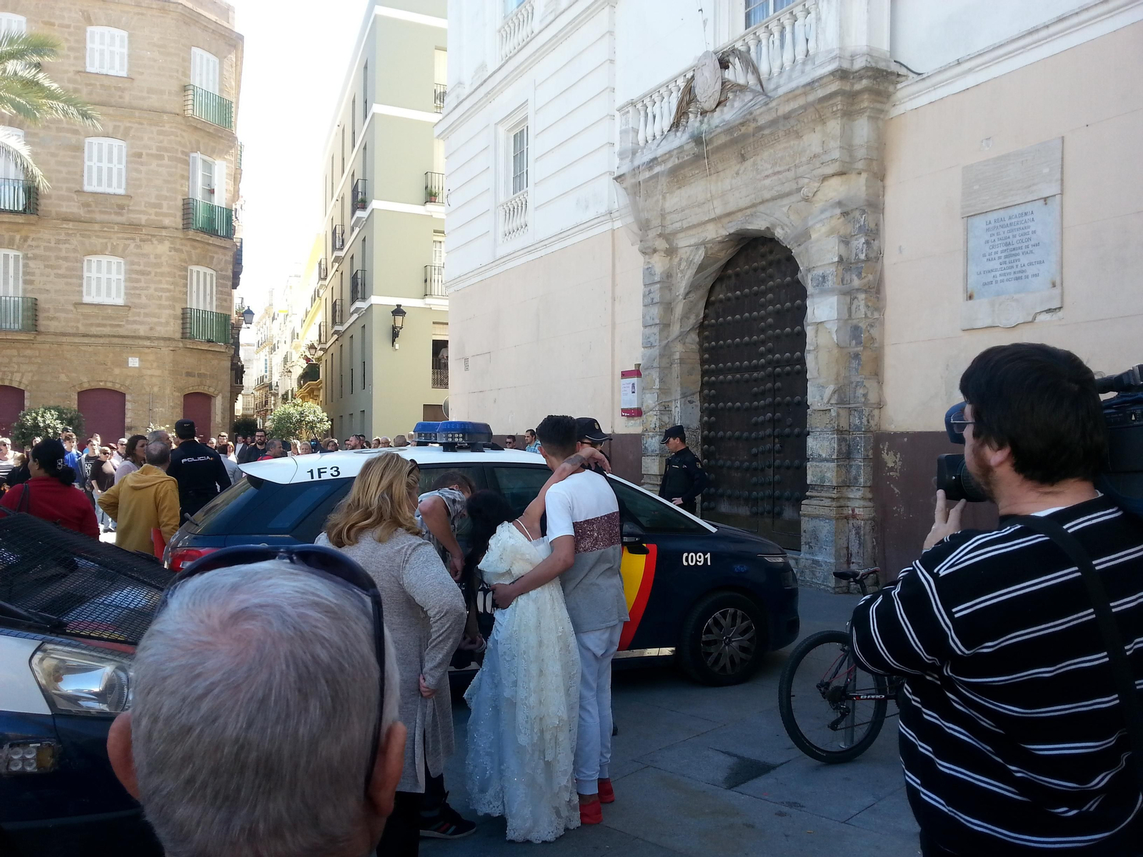 La novia con un familiar mientras los agentes custodian a la detenida.