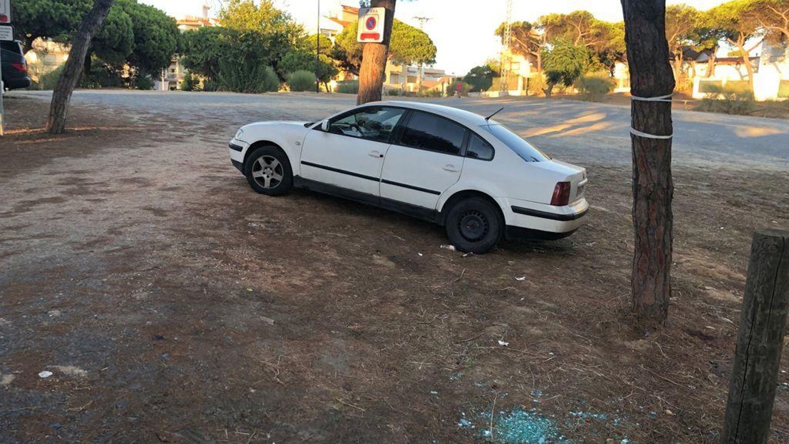 Restos de cristales rotos donde a primera hora de la tarde había un vehículo estacionado, en el descampado regulado como Zona Roja ORA en Punta Umbría.