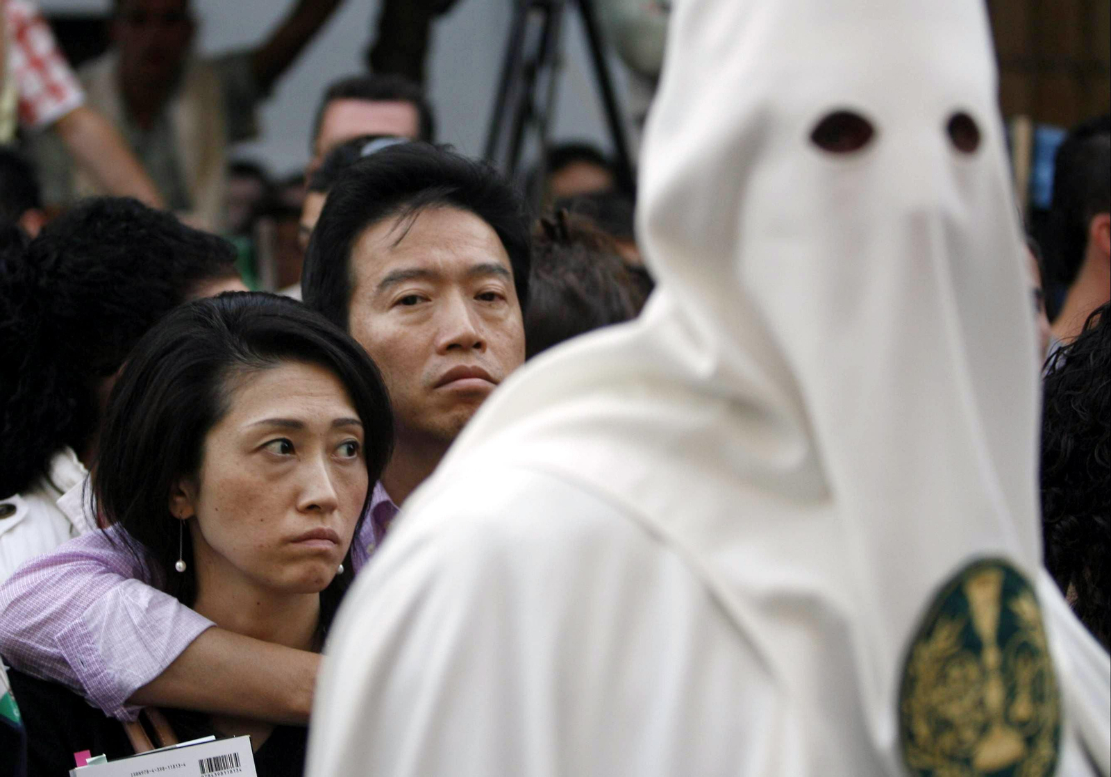 Turistas observando el paso de una procesión.