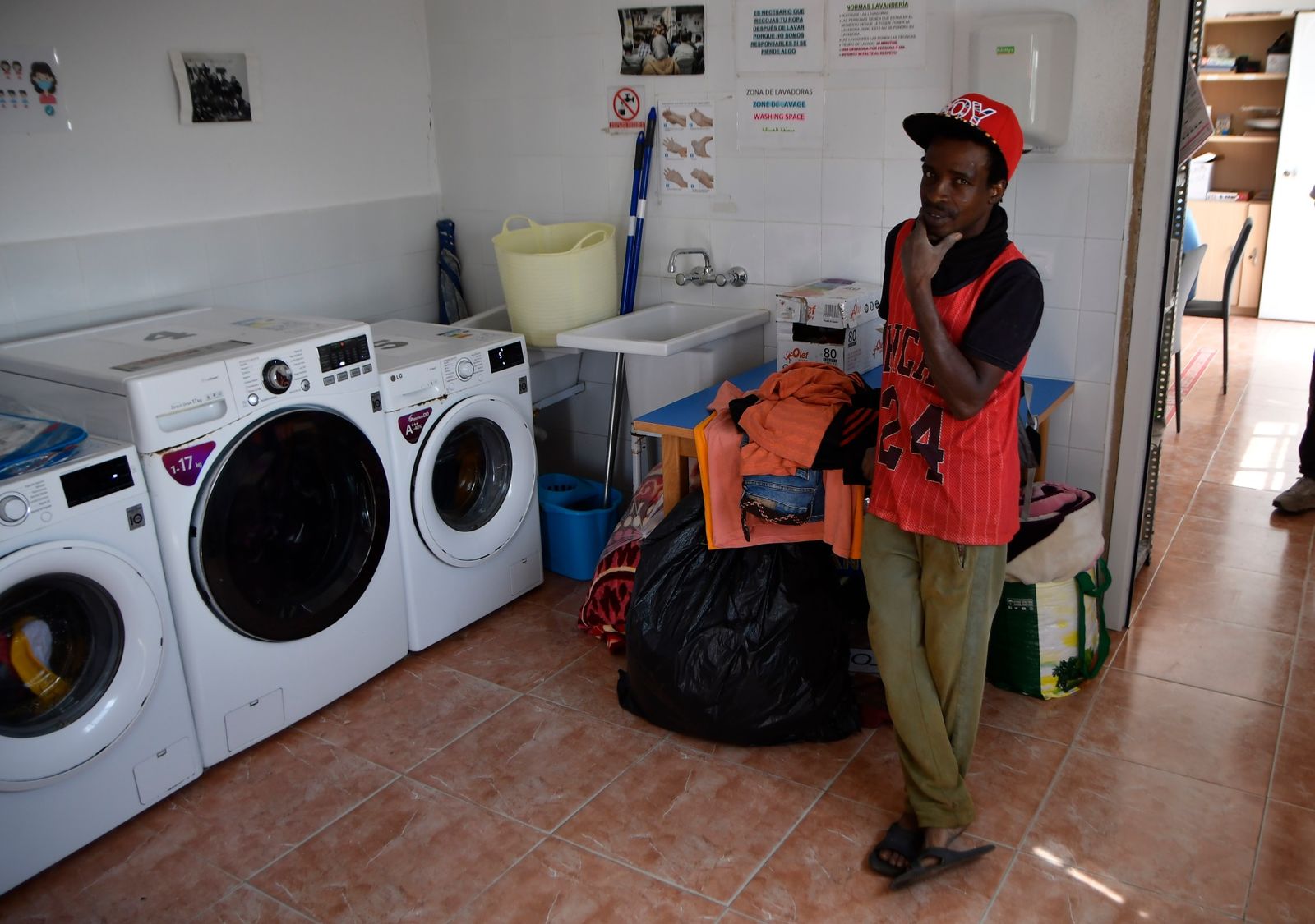 Un usuario pone una lavadora en el Centro de Día Almería Acoge