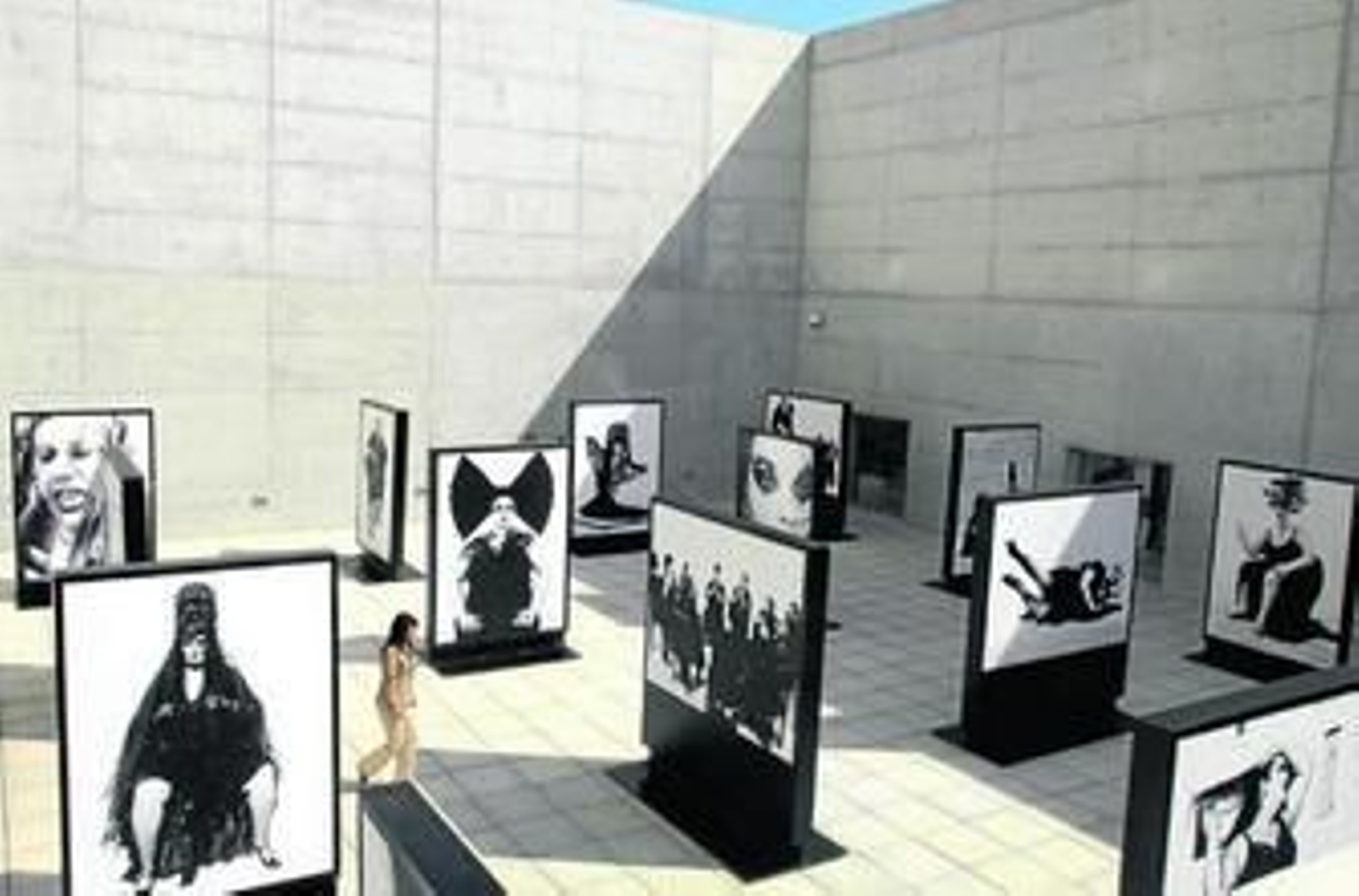 Una mujer pasea entre los retratos gigantes de Ruven Afanador que se pueden ver en el Museo de la Memoria.