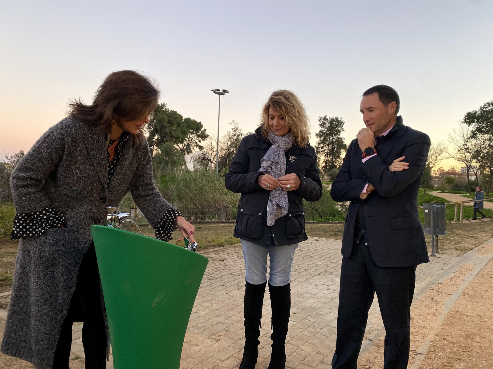 Mariló Ponce muestra a Pilar Miranda y a Pedro Peña el funcionamiento de una fuente.