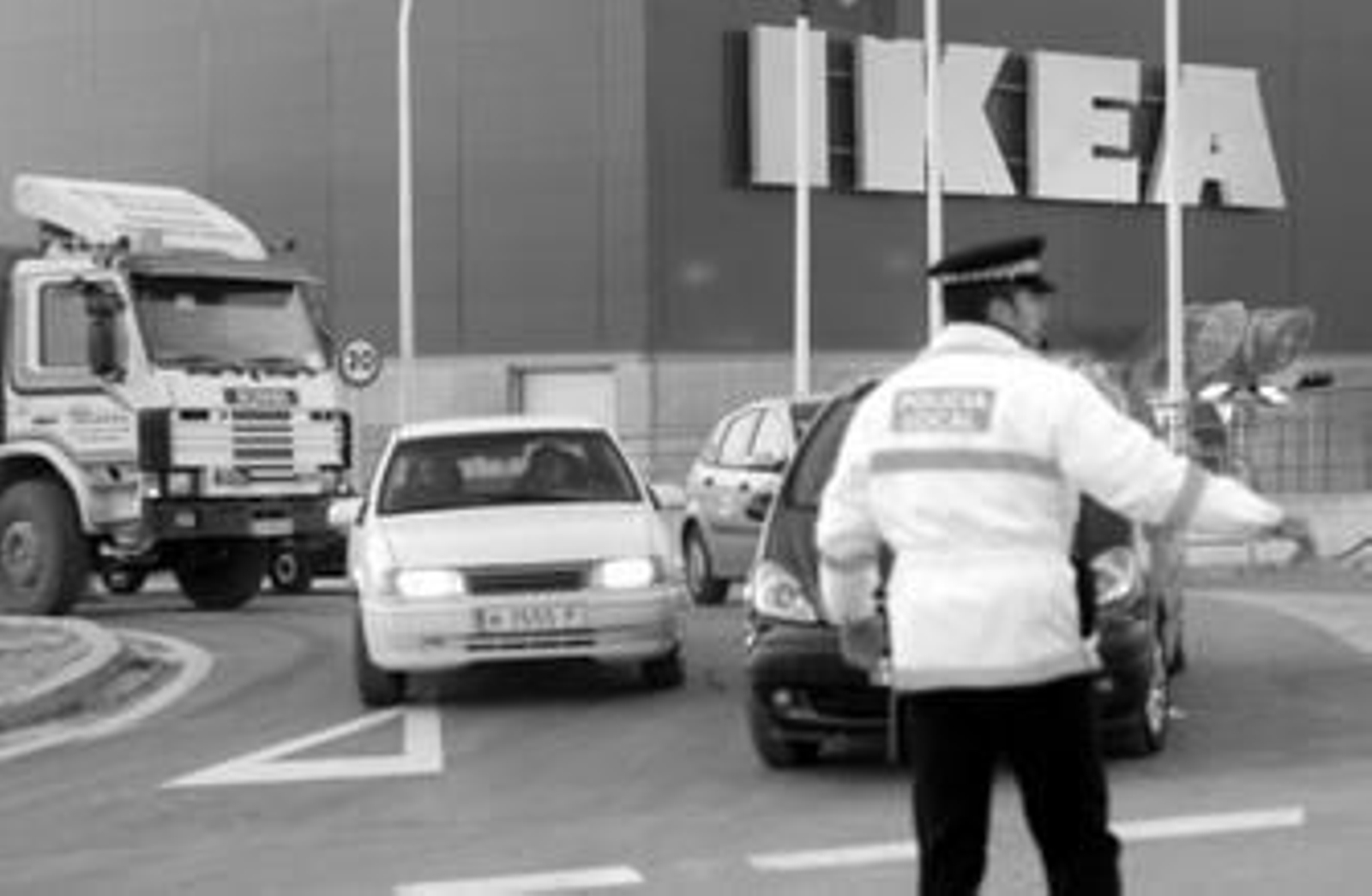 Un policía local regula el tráfico a la salida de Ikea Sevilla.
