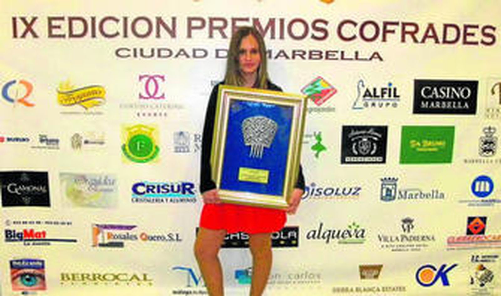 Imagen de Carmen Navarro junto al premio recibido.