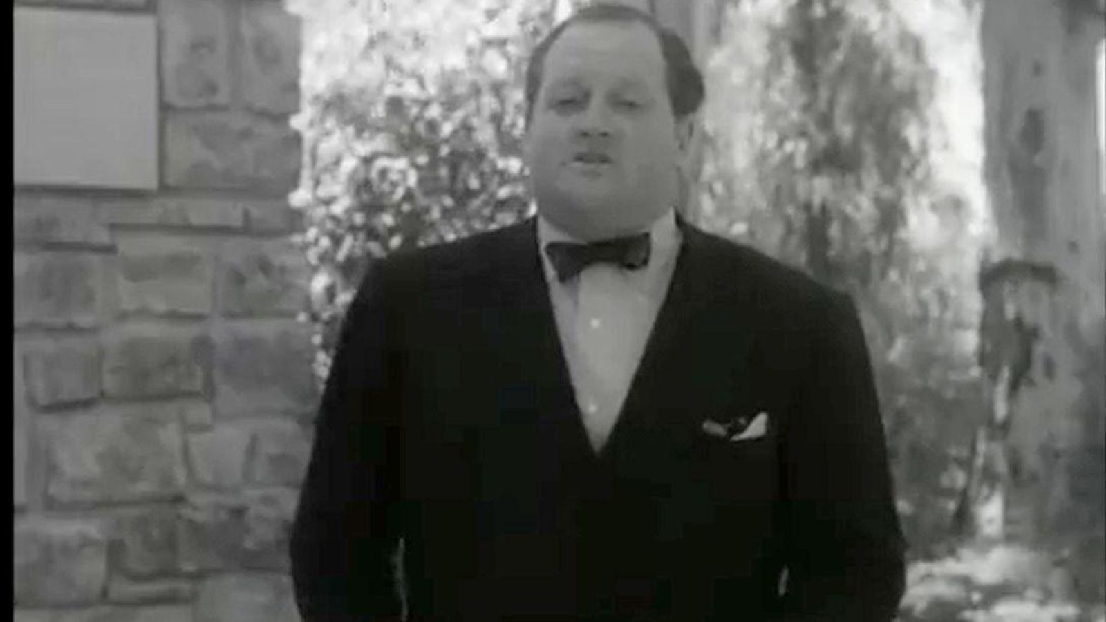 El periodista Richard Dimbleby junto al monumento a Shakespeare, 1956.