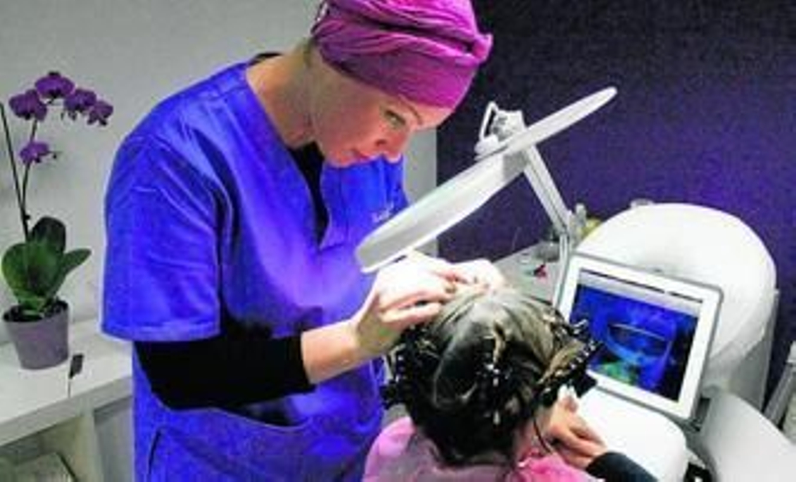 Una pequeña ve un DVD de dibujos animados mientras Mercedes Oloriz completa el tratamiento.