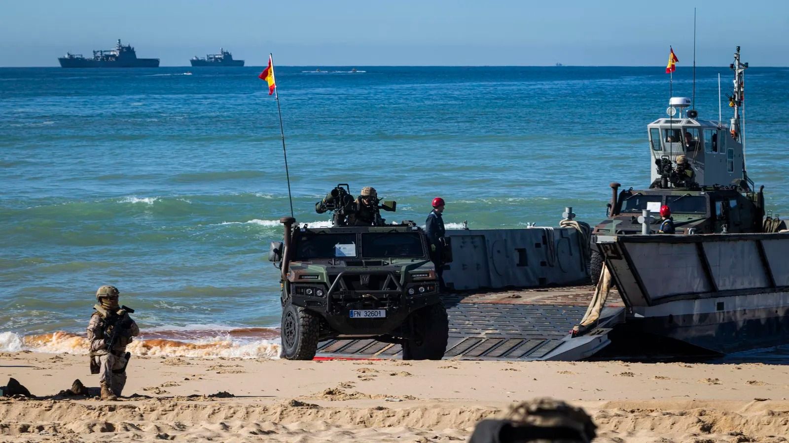 Un desembarco anfibio en El Retín, con las lachas llegando a la playa y los buques al fondo.