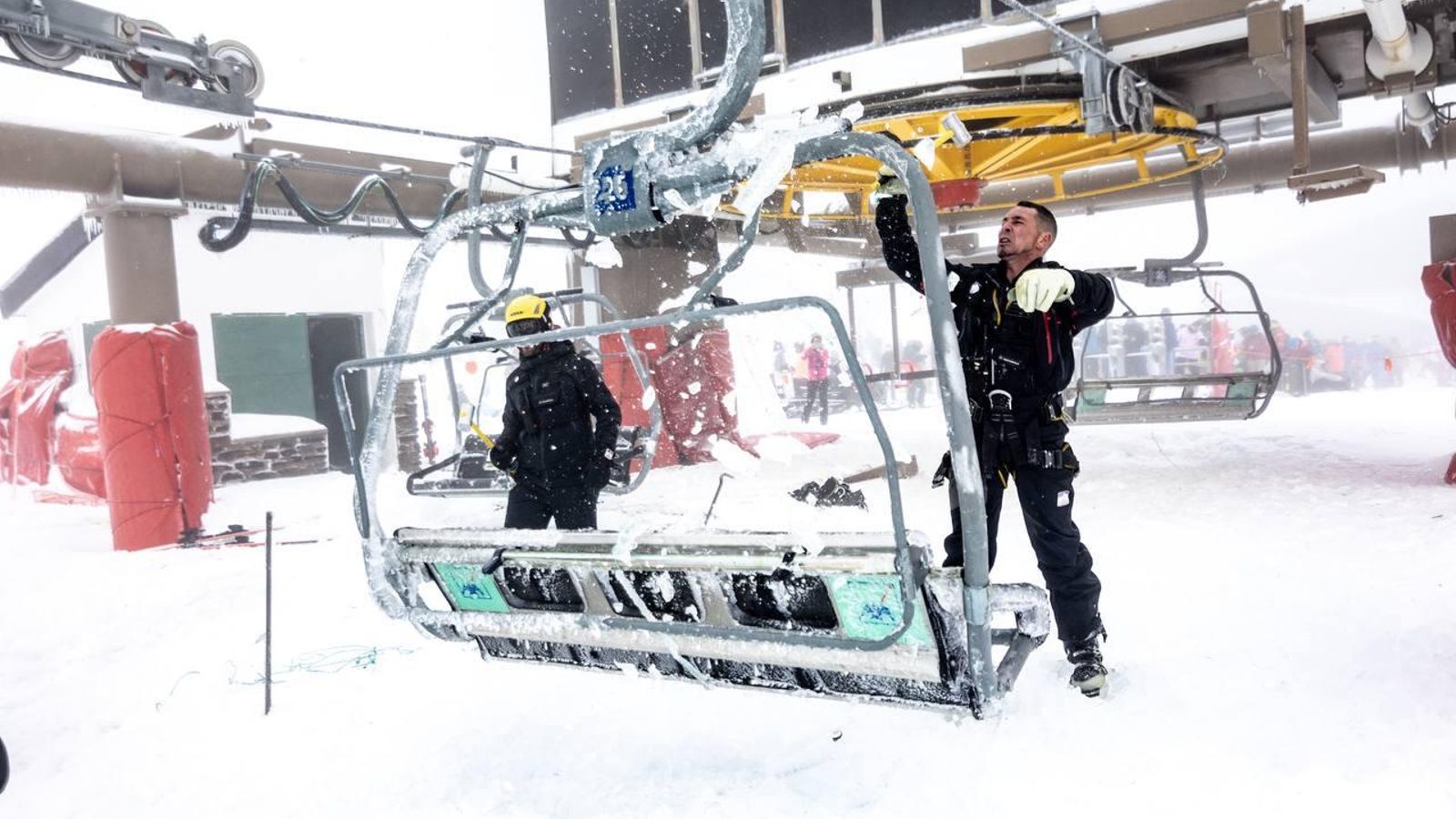 Un operario rompe el hielo acumulado en una silla del remonte de Borreguiles