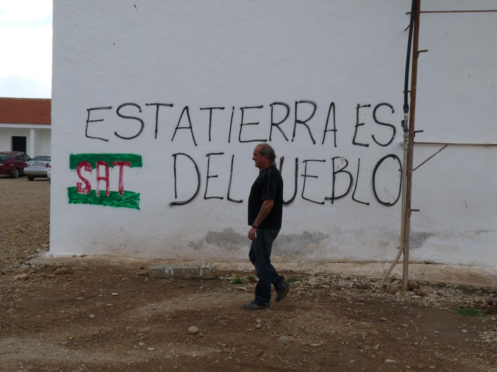 Un trabajador pasa ante una de las pintadas realizadas en una de las paredes de Somonte.