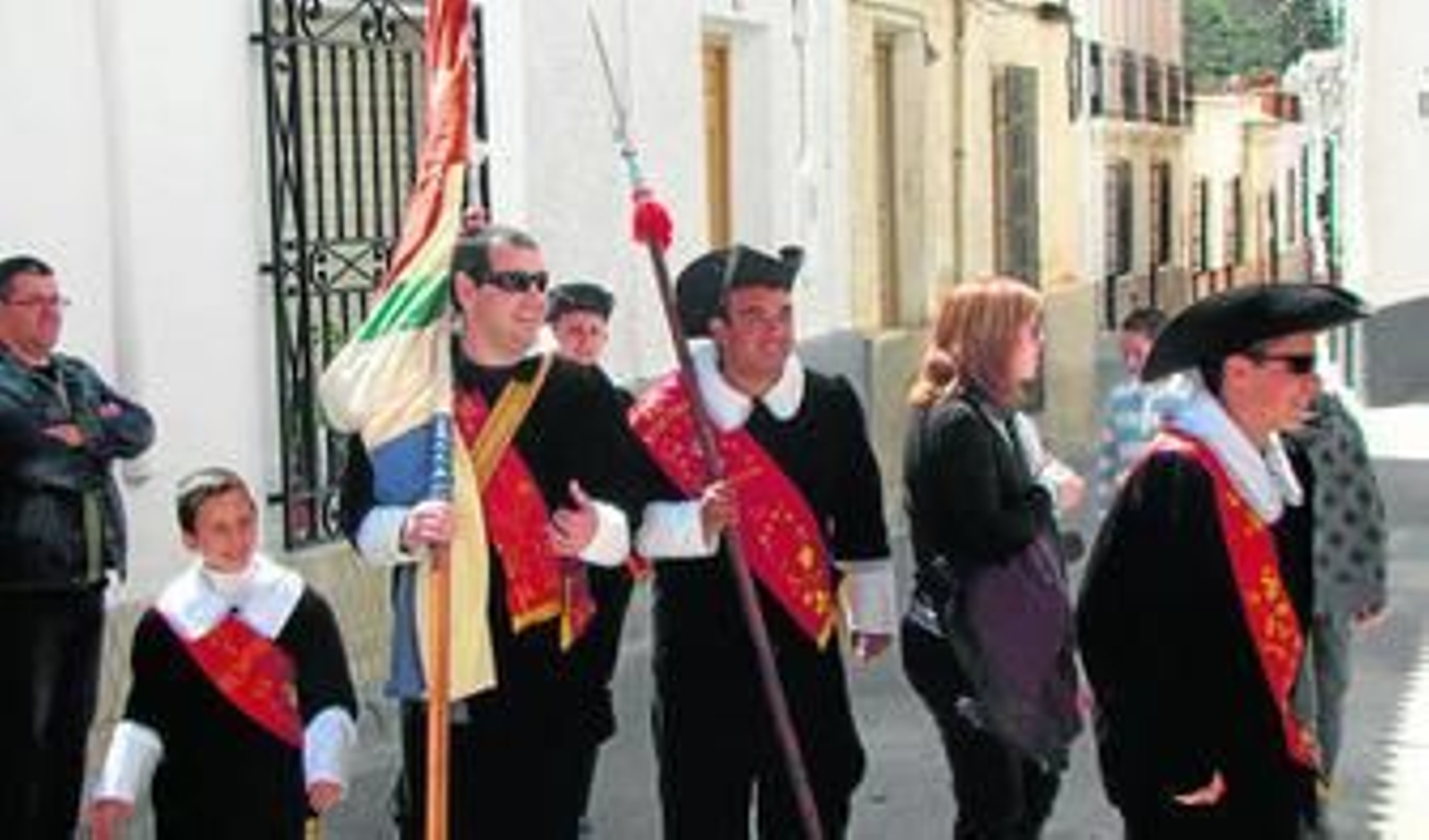 El abanderado que porta la bandera junto a otro de los miembros de la Hermandad en la Cardoncha de 2012.